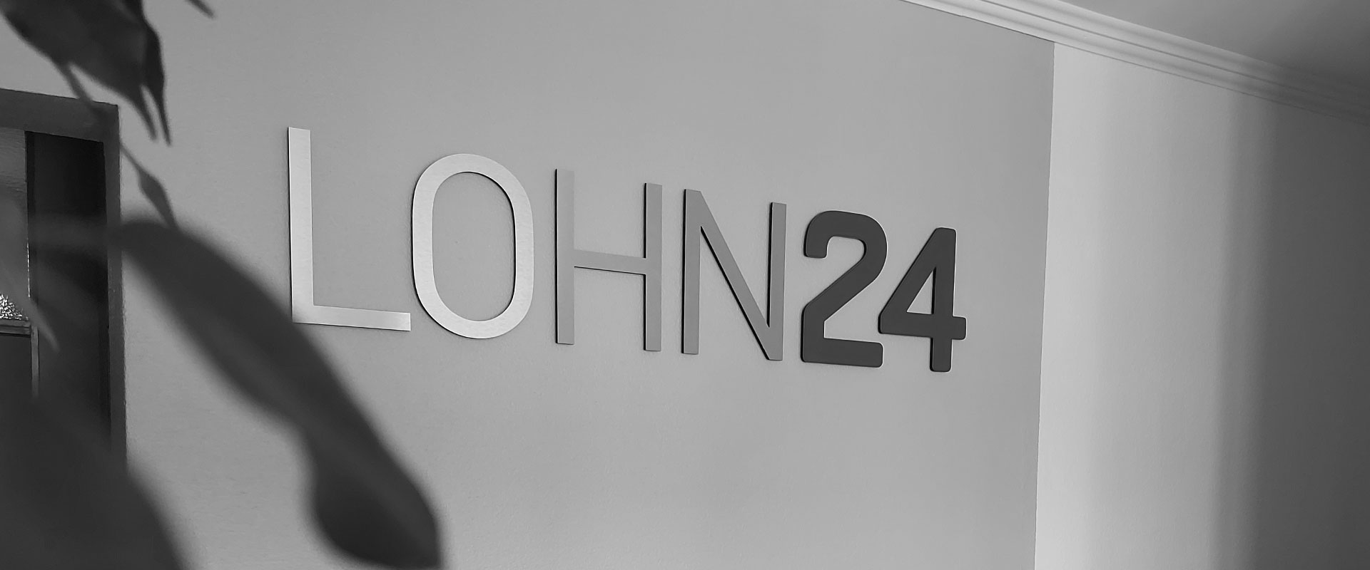 Das Logo der LOHN24 als Metallbuchstaben im Foyer